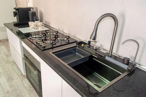 A modern kitchen with a gas stove, a built-in sink, and a coffee maker. - 2 apartments for up to 8 guests in Estoril beach (Sal Rei)