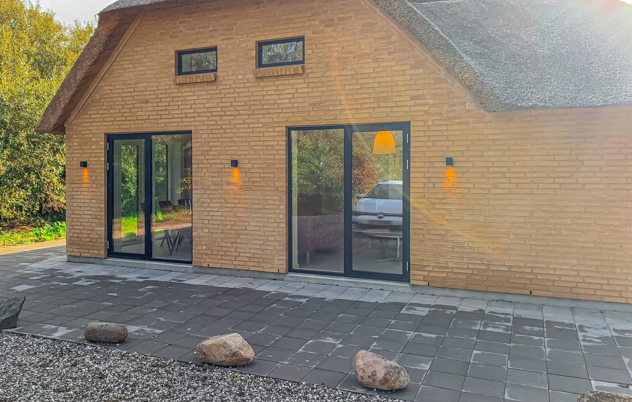 A building with a brick facade, large glass doors, and outdoor seating.