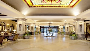 A spacious lobby with a large stained glass ceiling, columns, and potted plants. - Luxury 2BR Villa at Villa La Estancia – Stunning Views, Infinity Pools & Spa (Nuevo Nayarit)