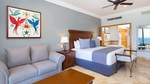 A hotel room with a bed, a sofa, a coffee table, and a painting on the wall. - Luxury 2BR Villa at Villa La Estancia – Stunning Views, Infinity Pools & Spa (Nuevo Nayarit)