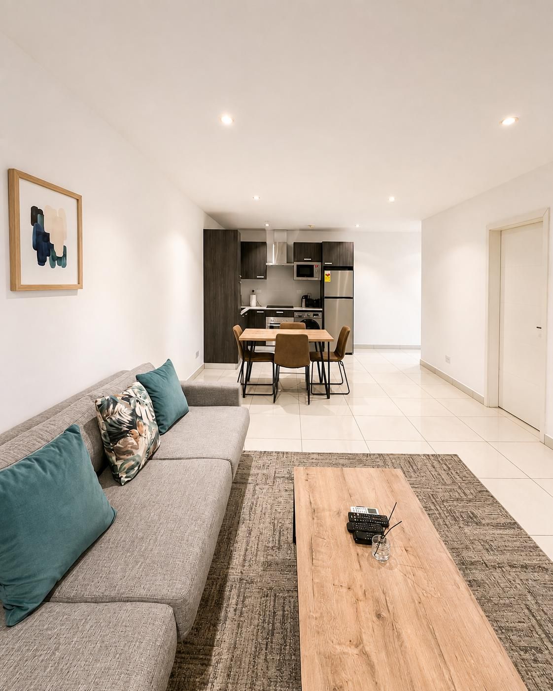 Un salon moderne comprenant un canapé, une table basse et un coin repas avec des chaises et une table.