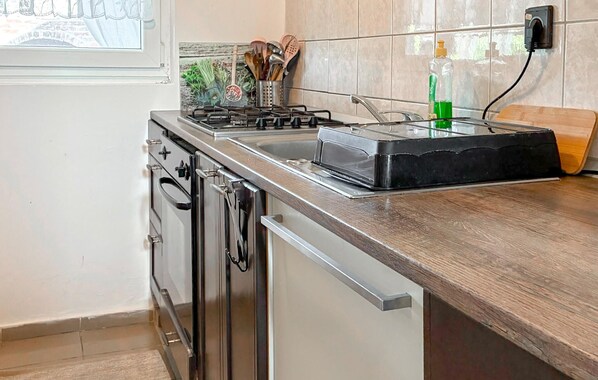 A kitchen with a stove, oven, and a built-in toaster. There is a window with a view of greenery outside. - Pet friendly home in Klostar Podravski with house a panoramic view (Klostar Podravski)