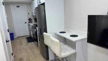 A compact kitchen with a refrigerator, a microwave, and a small countertop.