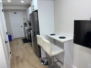 Une cuisine compacte équipée d’un réfrigérateur, d’un four à micro-ondes et d’un petit plan de travail.