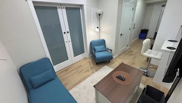 A modern living room with a sofa, a coffee table, and a blue armchair.