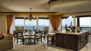 A spacious dining area with a view of the sea, a chandelier, and a bar area with decorative items. - Villa del Palmar Cancun - Oceanfront 2BR Suite, Terrace Jacuzzi (Punta Sam)