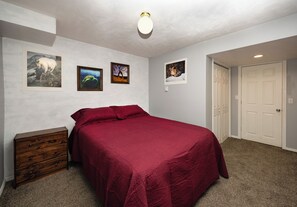A bedroom with a bed, a dresser, and three framed pictures on the wall. - Location, Location, Location (Sandy)