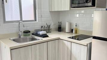 A modern kitchen with a built-in microwave, two sinks, and a window above the sink.