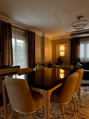 A hotel dining room with a rectangular table, six chairs, a modern chandelier, and a view through the window. - 3-bedroom apartment in maadi with air conditioning (Cairo Governorate)