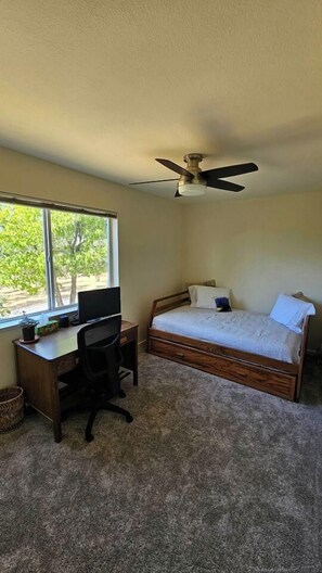 A bedroom with a bed, desk, chair, and a ceiling fan. - The Ranch Near the River- Hot tub -outdoor dining (Nevada City)