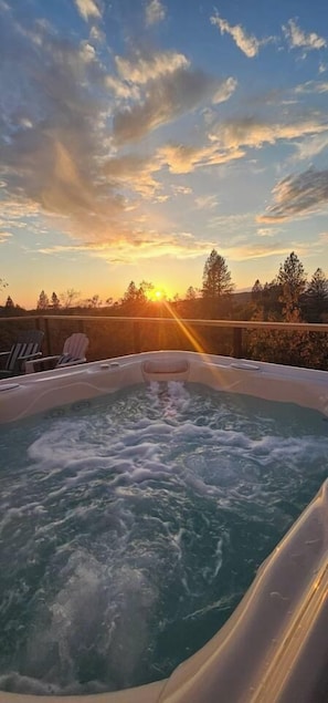 A hot tub with a view of the sunset and trees in the background. - The Ranch Near the River- Hot tub -outdoor dining (Nevada City)