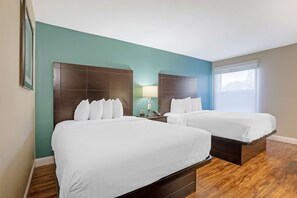 A hotel room with two beds, a nightstand, a lamp, and a window. - Best Western Plus Lonoke 2 Queen Studio (Lonoke)