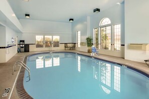 An indoor swimming pool with clear blue water, a ladder, and a bench. - Best Western Plus Lonoke 2 Queen Studio (Lonoke)