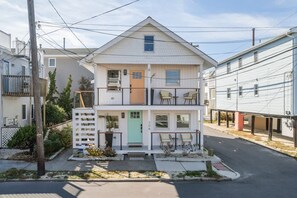 Ein zweistöckiges Wohnhaus mit Veranda, Garage und kleinem Vorgarten.