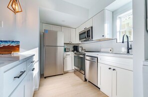 A modern kitchen with white cabinetry, stainless steel appliances, and a wooden countertop. - 3BR Beach House Near Ocean City Boardwalk (Ocean City)