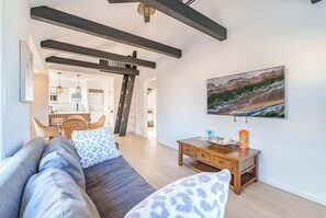 Ein Wohnzimmer mit einer Couch, einem Holztisch und einem Bild an der Wand.