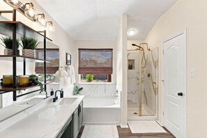A modern bathroom with a large bathtub, a shower, and a vanity with a sink. - Beach-Entry Pool Mini-Golf FirePit SeaWorld & BMT (San Antonio)