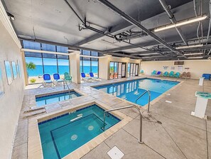 An indoor swimming pool with multiple lanes, surrounded by lounge chairs and a view of the ocean. - Spacious 3BR Coastal Getaway at Sand Dunes (Myrtle Beach)