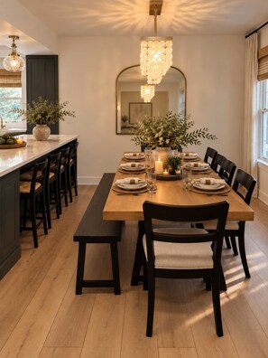 A dining room with a long wooden table set for six, surrounded by black chairs. - Carriage House on 32nd (Billings)