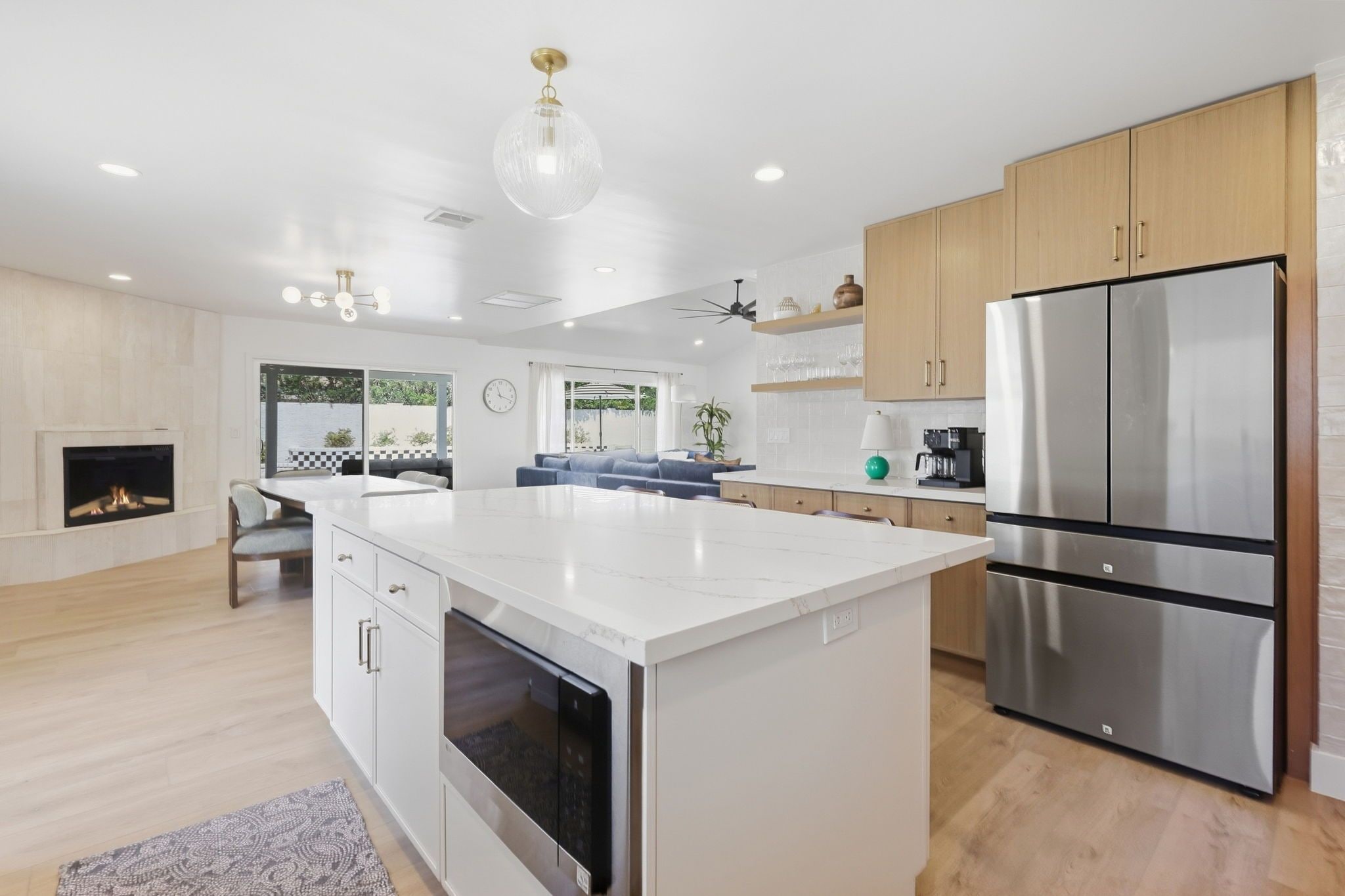 Een moderne keuken met een centraal eiland, roestvrijstalen apparatuur en een open haard.