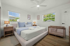 A bedroom with a bed, bedside lamps, a crib, and windows with blinds. - Pool Home | Fenced Yard | 9 Min to Beach (Venice)