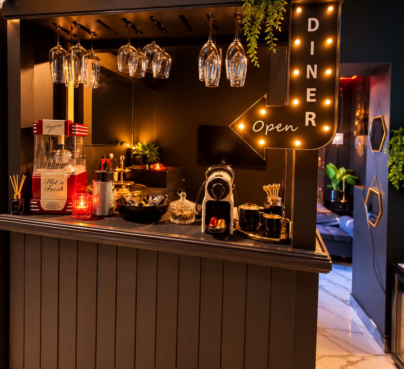 A bar area with a sign indicating it's open, a bottle of hot water, a candle, and various bar tools.