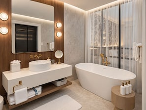 A modern bathroom with a freestanding bathtub, a vanity with a mirror, and a large mirror above the vanity. - Beachfront Retreat, Ocean Views & Boutique Luxury (George Town)