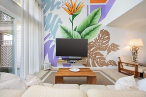 A modern living room with a flat-screen TV, a wooden coffee table, and a sofa. - Hilton Pool Pass 2026-27 | Sunset Family Villa 3bd (Waikoloa Village)