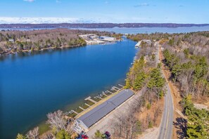 A lakeside property with a dock, a parking area, and a road leading to the water. - Clam Lake Terrace Retreat (Bellaire)