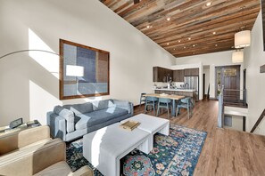 Uma sala de estar moderna com um sofá, mesa de centro e um espaço de jantar com cadeiras.