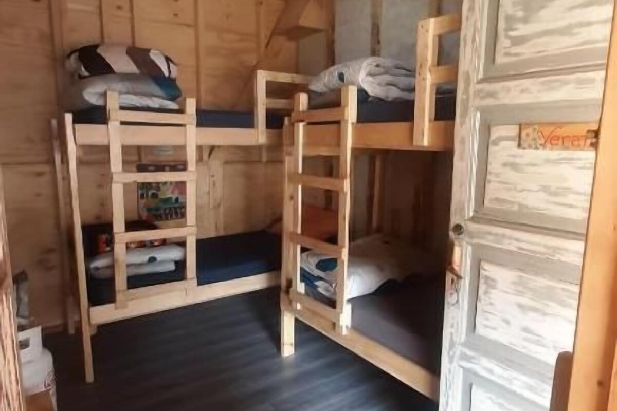 Een houten interieur met stapelbedden en een deur.