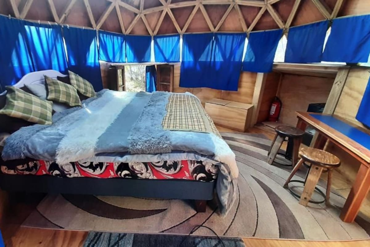 Een kamer met een bed, een klein tafeltje en een stoel.