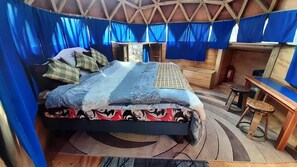Een kamer met een bed, een klein tafeltje en een stoel.