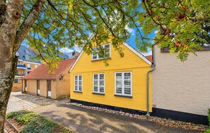 A yellow house with a red roof, a stone pathway, and a tree in the foreground. - Lovely home in Aabenraa with WiFi (Aabenraa)