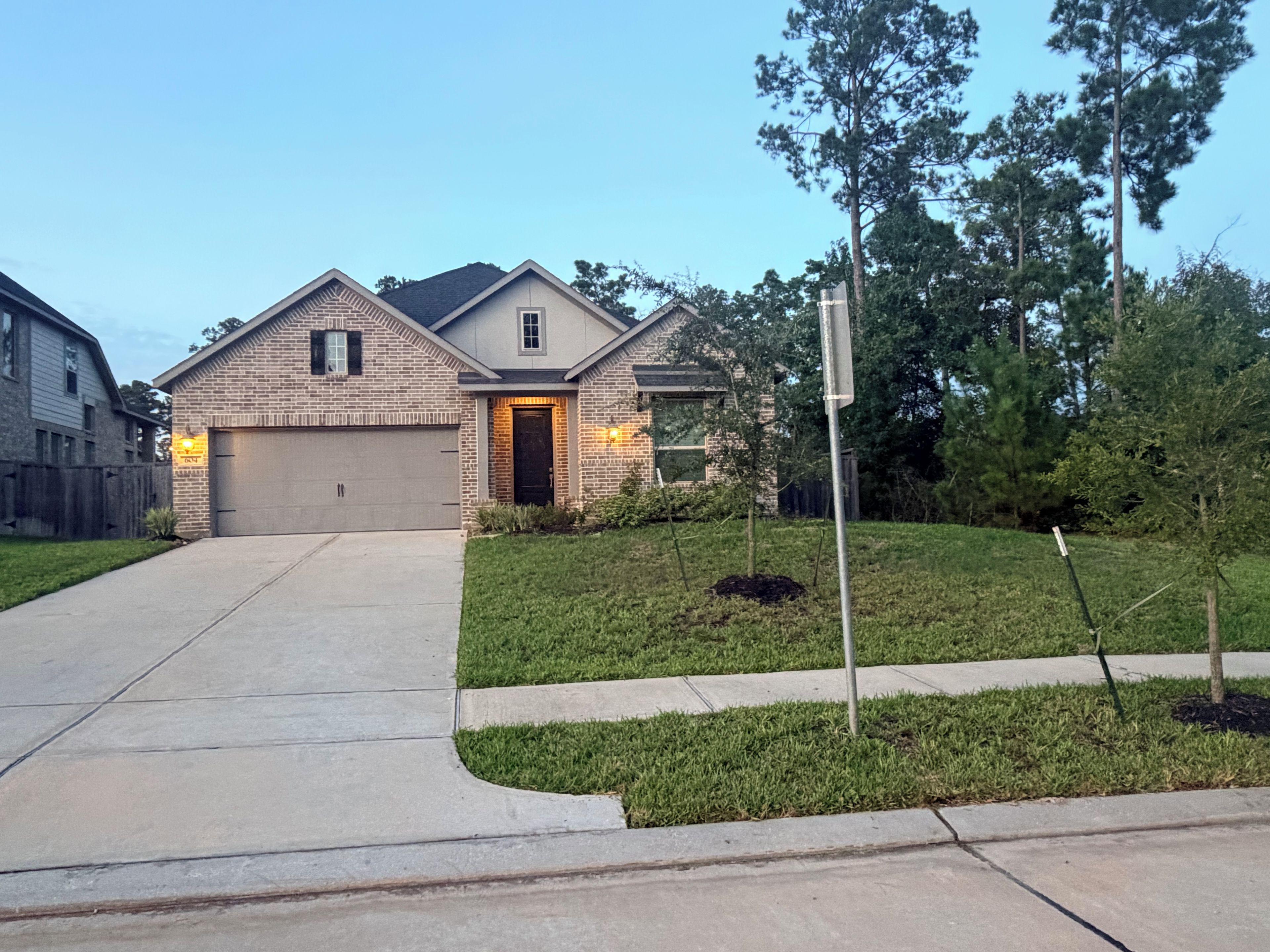 A residential house with a garage, a driveway, and a well-maintained lawn.