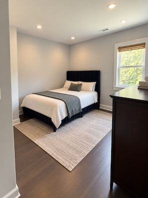 Un dormitorio con cama, ventana y escritorio.