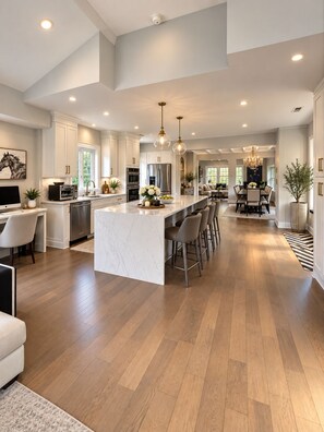 A spacious kitchen with a large island, modern appliances, and pendant lighting. - Spacious 4-bedroom house in amazing Great Falls (Great Falls)