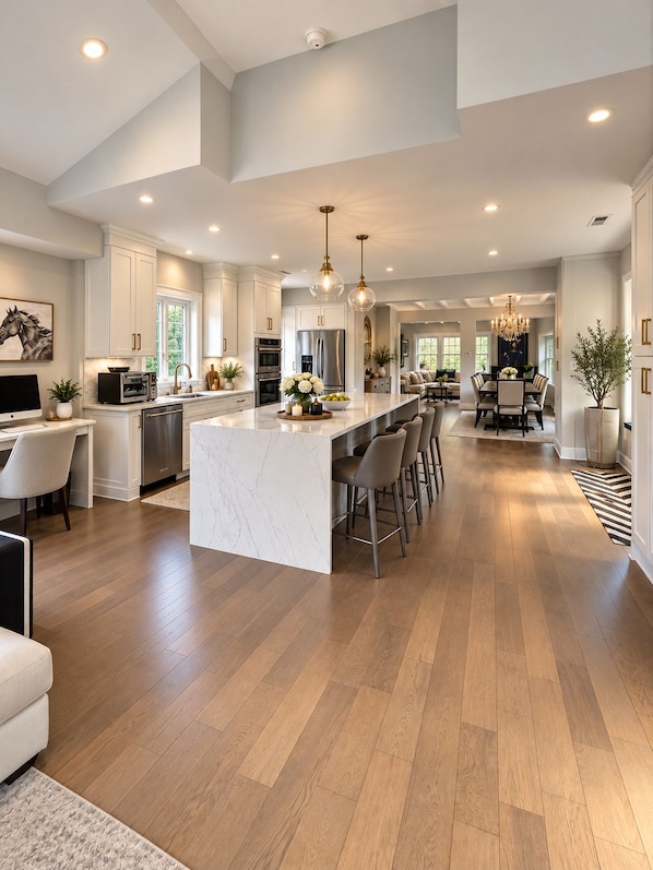 A spacious kitchen with a large island, modern appliances, and pendant lighting.