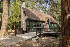 Eine rustikale Holzhütte mit einer Holzterrasse und einer Brücke zum Eingang.