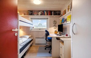 A compact room with a bunk bed, a desk with a computer, and a window with a view of a building. - 3 bedroom stunning home in Bogense (Bogense)