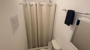 Un baño pequeño con inodoro, lavabo y cortina de ducha.