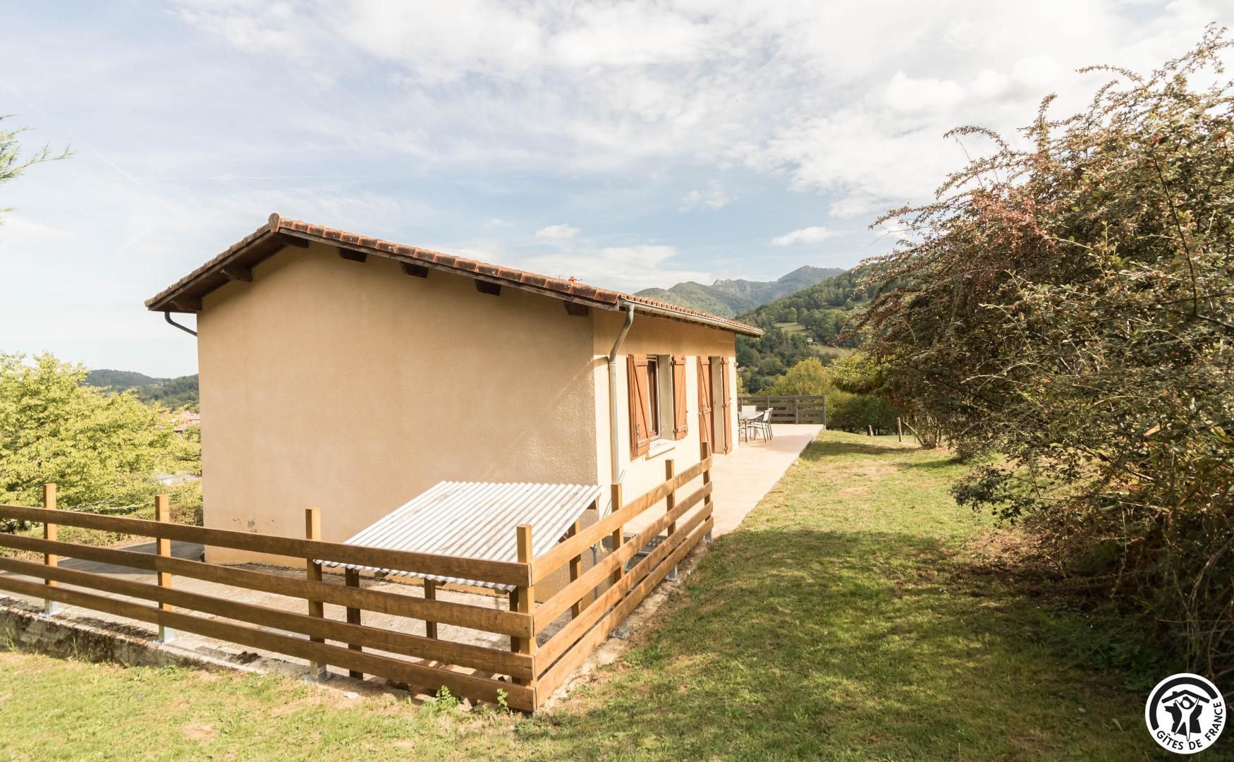 Un petit bâtiment doté d’un toit en pente, d’une clôture en bois et d’un chemin pavé menant à l’entrée.