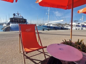 A marina with boats, a red chair labeled 'APEROL SPRITZ', and a table with a pink surface. - Tranquil Mountain Retreat With Private Pool in Quesa, Valencia (Quesa)