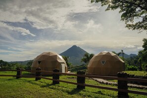 Two geodesic dome structures with a mountain in the background. - Luxury Glamping Dome - 2 beds - with amazing Arenal Volcano and Lake views (El Castillo)