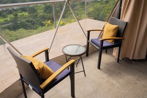 A balcony with two chairs and a small round table. - Luxury Glamping Dome - 2 beds - with amazing Arenal Volcano and Lake views (El Castillo)