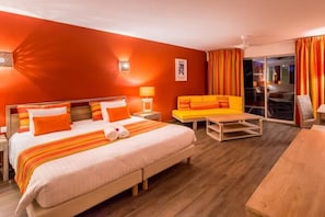 Een hotelkamer met een groot bed, een bank, een houten tafel en uitzicht.