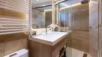 Une salle de bain moderne avec un meuble-lavabo en bois, une cabine de douche en verre et un grand miroir.