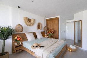 Een slaapkamer met een bed, nachtkastjes, een spiegel en een kledingkast.