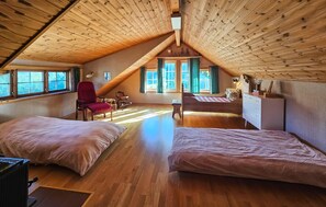 A loft bedroom with a sloped ceiling, wooden beams, a bed, a desk, and a chair. - Gorgeous home in Passebekk with house a panoramic view (Passebekk)