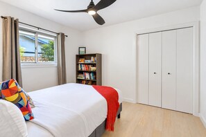 A bedroom with a bed, a bookshelf, a wardrobe, and a ceiling fan. - 4BR Austin Escape Sleeps 9 | Patio, & Fire Pit (Austin)